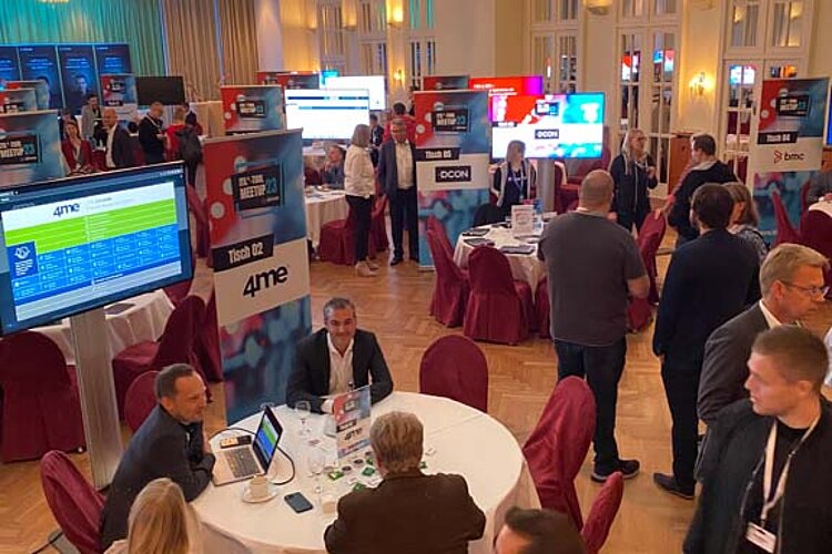 SERVIEW TOOL MEETUP participants sit at round tables in an elegant hall with chandeliers and LED ceiling lighting and discuss with exhibitors.