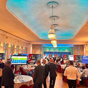 SERVIEW TOOL MEETUP participants sit at round tables in an elegant hall with chandeliers and LED ceiling lighting and discuss with exhibitors.