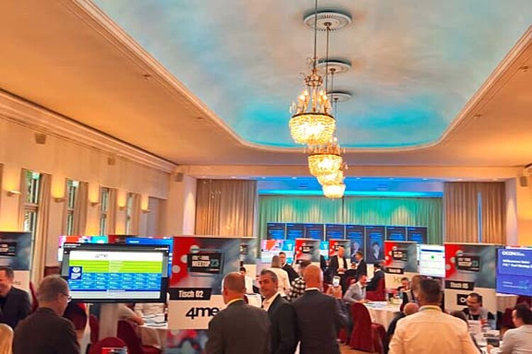 SERVIEW TOOL MEETUP participants sit at round tables in an elegant hall with chandeliers and LED ceiling lighting and discuss with exhibitors.