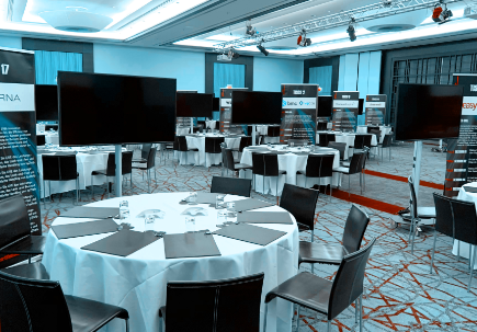 Prepared conference room with round tables, screens and name badges for exhibitors at the SERVIEW TOOL MEETUP.